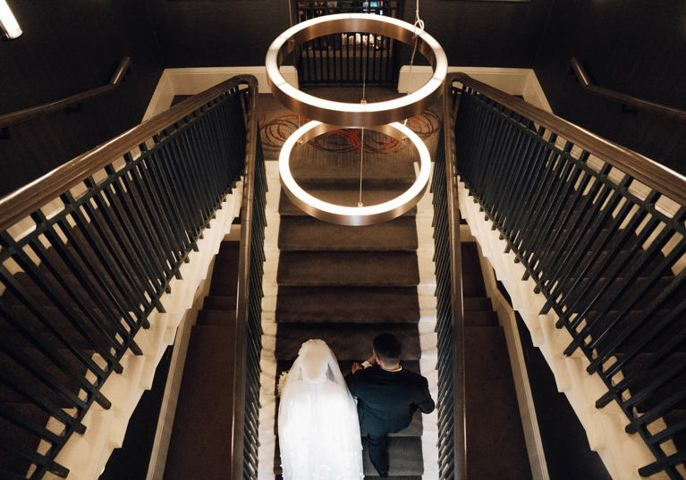 View from above of bride and groom walking up stairs